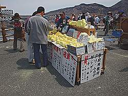 Aso - de vulkaan Mount Aso; stukken zwavel, uit het kratermeer, worden te koop aangeboden