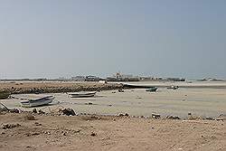 Al Ruwais - vissersboten op het strand, met de vissershaven op de achtergrond