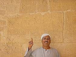De piramiden van Abu Sir - een van de bewakers wijst een heroglief aan