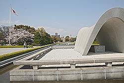 Hiroshima - gedenkteken voor de slachtoffers van de atoombom; daarachter de eeuwige vlam ter nagedachtenis