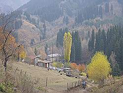 Bergtocht in de herfst - uitzicht over de buitenwijk van Almaty