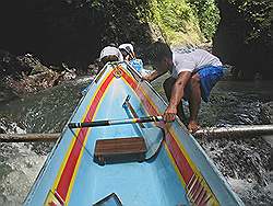 Pagsanjan - als het water laag staat, worden de boten op ondiepe plaatsen over platliggende boomstammen heen getrokken; voorkomt beschadiging van de boot door de stenen