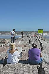 Galveston - het strand met een strekdam; twee dames aan het tekenen